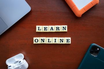 Letter tiles spelling Learn Online beside a laptop and headphones