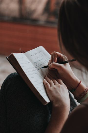 A learner writing notes in a journal