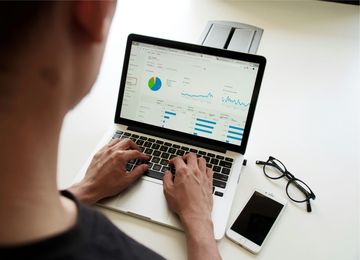 A professional reviewing website analytics on a laptop